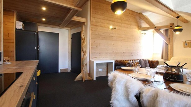 A cozy wooden interior with a dining area, a fireplace, and a modern kitchen. - 3rd floor, tv, ski locker, 100m², Serre Chevalier (Briançon)