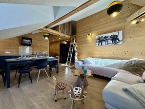 Et moderne interiør med et spisebord, en sofa og en stige.
