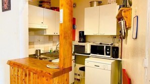 A compact kitchen with white cabinets, a wooden countertop, a microwave, and a coffee maker. - 7th floor, balcony, parking, tv, 63m², Villard de Lans (Villard-de-Lans)