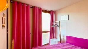 A room with a bed, a window with curtains, a coat rack, and a door. - 7th floor, balcony, parking, tv, 63m², Villard de Lans (Villard-de-Lans)