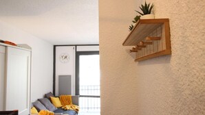 A room with a bed, a wardrobe, a small plant shelf, and a window with a view. - 300m from ski slopes, 7th floor, balcony, tv, 19m², Chamrousse (Chamrousse)