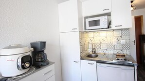 A compact kitchen with a coffee maker, a microwave, and a sink. - 300m from ski slopes, 7th floor, balcony, tv, 19m², Chamrousse (Chamrousse)