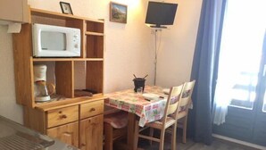 A compact kitchen with a microwave, coffee maker, and a small dining table with chairs. - 50m from ski slopes, 1st floor, view mountain, balcony, tv, ski locker, 20m², Risoul (Risoul)