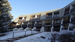 Ein mehrstöckiges Gebäude mit Balkonen und einem verschneiten Innenhof.