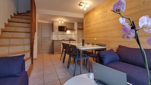 Una sala de estar moderna con una escalera, un comedor y una cocina.