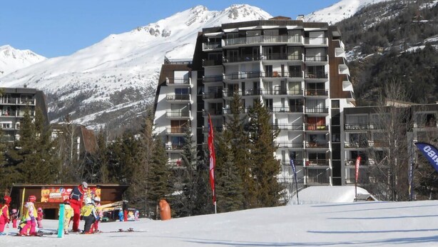 A multi-story hotel with balconies, set against a snowy mountain backdrop. - 50m from resort center, 5th floor, balcony, tv, ski locker, 28m², Serre Chevalier (La Salle-les-Alpes)