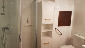 A bathroom with a glass-enclosed shower, a toilet, and a shelf unit with drawers. - 50m from ski slopes, 3rd floor, swimming pool, 37m², Valloire (Valloire)