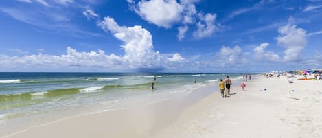 Una playa con cielos despejados y aguas tranquilas.