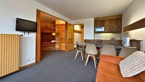 A compact living space with a kitchenette, a dining area, and a sofa. - 10m from ski slopes, 7th floor, balcony, tv, 28m², Les Menuires (Les Menuires)