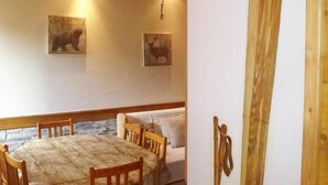 A dining area with a wooden table and chairs, a ceiling fan, and two wall-mounted animal pictures. - 300m from ski slopes, parking, tv, 44m², Arêches-Beaufort (Beaufort)