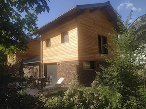 A two-story wooden house with a patio area.