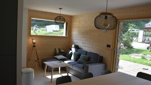 Un intérieur moderne avec un mur en bois, un canapé, une table et un lampadaire sur trépied.