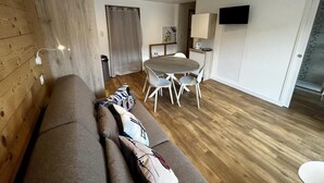 A modern living room with a sofa, dining table, and chairs. - 10m from ski slopes, 2nd floor, view mountain, tv, ski locker, 27m², Les Menuires (Les Menuires)