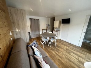 Ein modernes Wohnzimmer mit einer Couch, einem Esstisch und Stühlen.