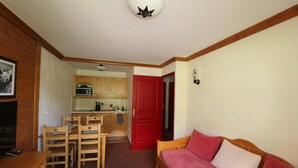 A compact living space with a kitchenette, a dining area, and a sofa.