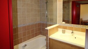 A bathroom with a bathtub, a sink, and a shower.