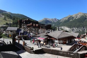 A mountain resort with a ski lift, wooden buildings, and a view of the surrounding mountains.