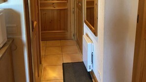 A narrow hallway with wooden doors and a radiator on the wall. - 50m from ski slopes, 1st floor, view mountain, balcony, tv, ski locker, 29m², Les Saisies (Les Saisies)