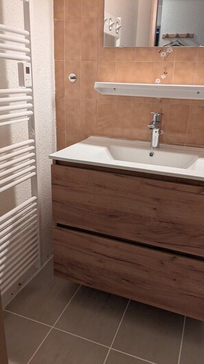 A bathroom with a white sink, wooden vanity, and a towel rack. - 200m from resort center, 4th floor, tv, 25m², Orcières Merlette 1850 (Orcières)