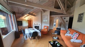 A modern living room with a dining area, wooden floors, and a staircase leading to another level. - 4th floor, view resort, fireplace or stove, parking, tv, ski locker, 160m², Serre Chevalier (La Salle-les-Alpes)