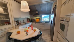 A modern kitchen with white cabinets, a central island, and a view of the outdoors. - 4th floor, view resort, fireplace or stove, parking, tv, ski locker, 160m², Serre Chevalier (La Salle-les-Alpes)