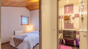 A bedroom with a bed, a nightstand, a window, and a wall-mounted picture. - 100m from ski slopes, 4th floor, balcony, ski locker, 37m², Montchavin La Plagne (Bellentre)
