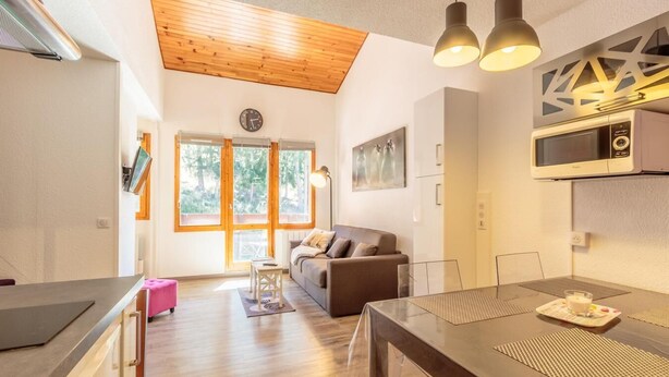 A modern kitchen with a dining area, wooden ceiling, and large windows. - 100m from ski slopes, 4th floor, balcony, ski locker, 37m², Montchavin La Plagne (Bellentre)