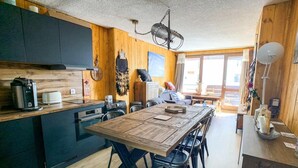 Eine gemütliche Küche mit Holzschränken, einem großen Holztisch und modernen Geräten.