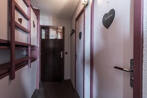 Enter a cozy hallway with a door leading to a space, featuring a decorative heart-shaped sign.