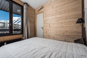 Enjoy breathtaking mountain views from the comfort of this cozy retreat, featuring a plush bed and warm radiator.