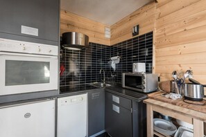 Enjoy cooking in this well-equipped kitchen with an oven, microwave, and range hood.