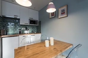 Enjoy meals together at the dining table, surrounded by pendant lights and framed artwork.
