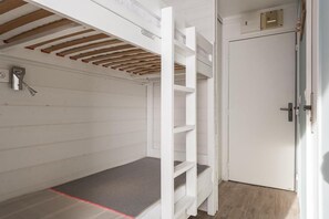 Cozy retreat with a bunk bed, wooden ceiling, and a small window.