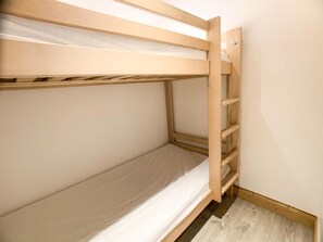 Uma cama beliche com estrutura de madeira e colchão.