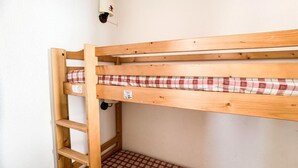 A bunk bed with a checkered mattress, a wooden ladder, and a wall-mounted light fixture. - 100m from resort center, 4th floor, balcony, tv, ski locker, 30m², Tignes (Tignes)