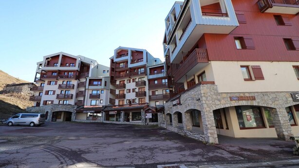 Et hotel med flere etager, altaner og en facade i sten.