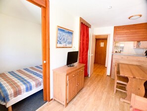 Cozy retreat with a single bed, dresser, and kitchenette.