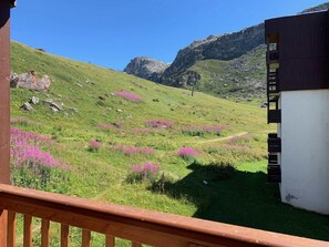 Enjoy breathtaking views from a balcony overlooking a serene hillside with purple flowers.