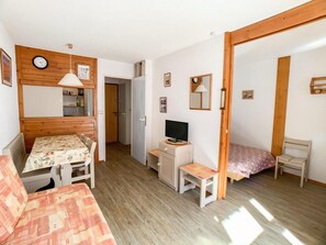 Cozy retreat with a functional layout, featuring a comfortable bed, desk, and TV.