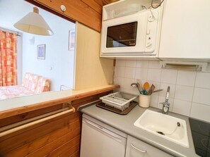 Kitchen features a window above the sink, a microwave, and a Bosch dishwasher, with a dish rack on the sink's edge.