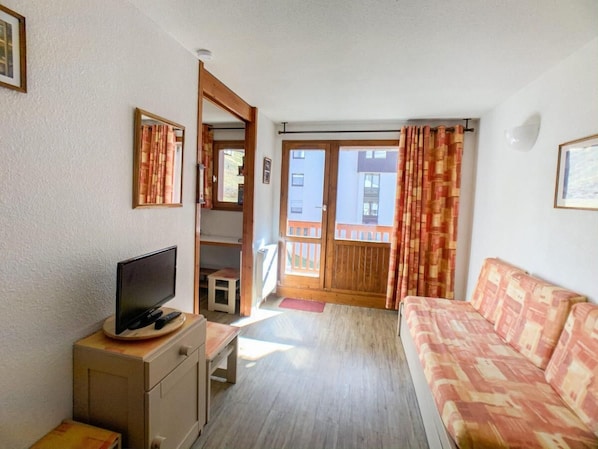 Relax in this cozy living space with a TV, sofa, and sliding door to an outdoor deck.