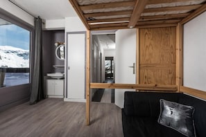 Enjoy a cozy retreat with a large window offering a view of the surrounding landscape, a comfortable sofa, and a modern bathroom.