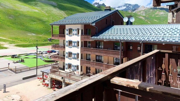 A multi-story hotel with balconies, a ski slope in the background, and a mountain view. - 100m from resort center, 4th floor, balcony, ski locker, 18m², Tignes (Tignes)