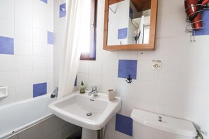 Bathroom features a sink, mirror, toilet, and shower with a hairdryer.