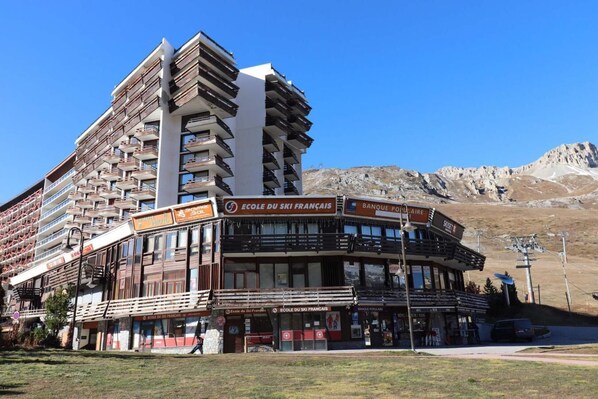 Located in a ski resort area, this building offers stunning mountain views and features a prominent ski school on the ground floor.