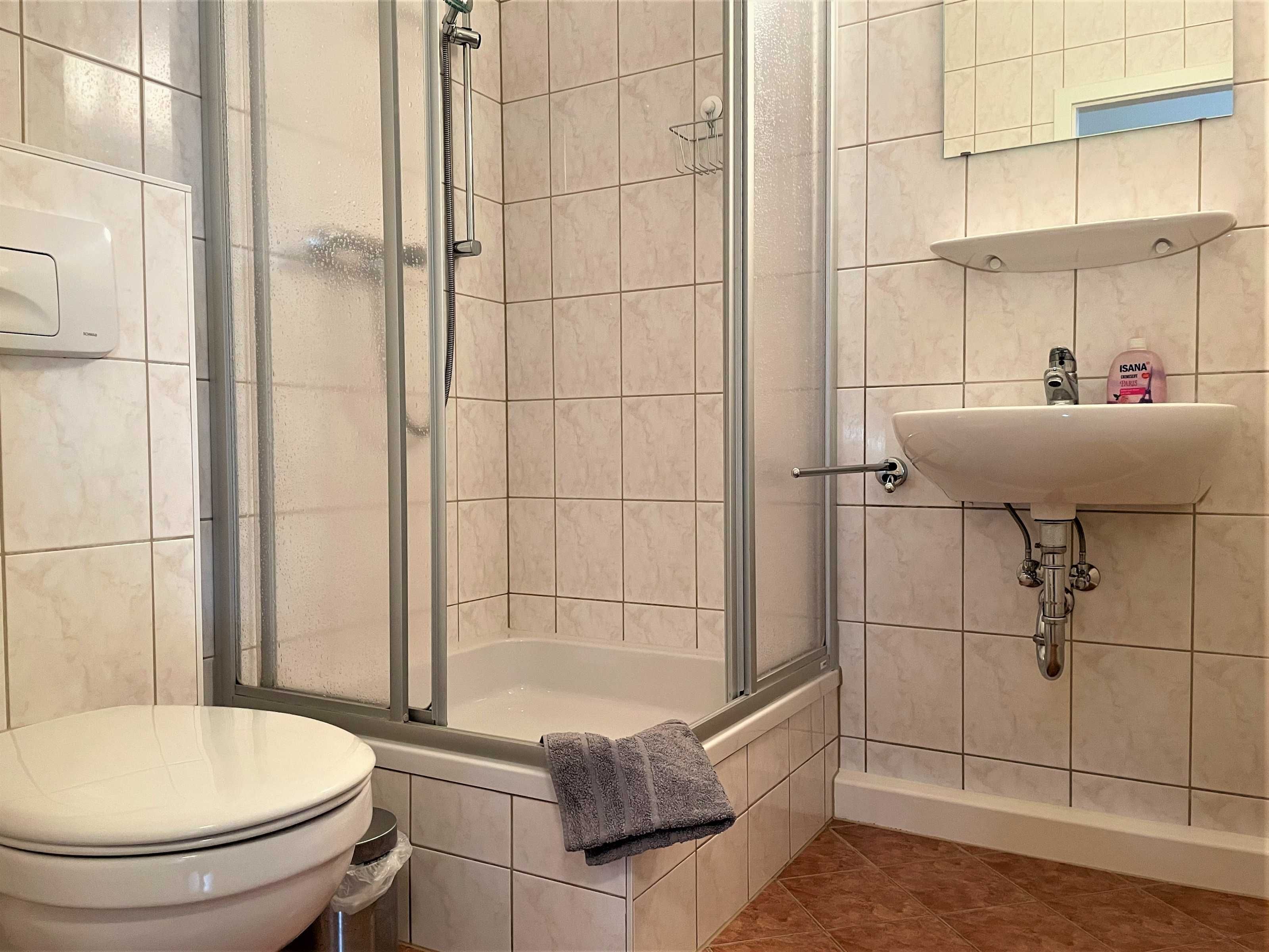 Ein Badezimmer mit Dusche, Toilette und Waschbecken.