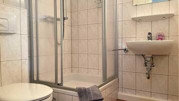 Ein Badezimmer mit Dusche, Toilette und Waschbecken.