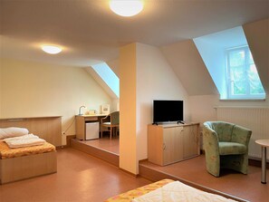 A compact room with a bed, a desk, a chair, a TV, and a window. - Ferienzimmer Nr. 34 - Schullandheim Reichwalde (Boxberg/Oberlausitz)