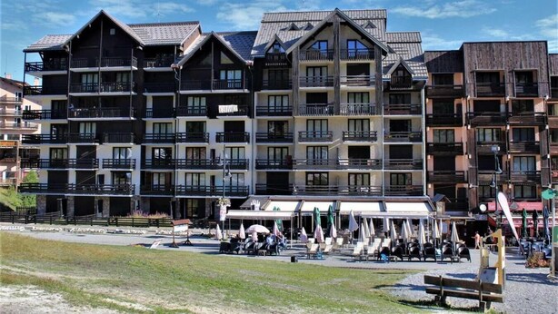A multi-story hotel with balconies, outdoor seating, and a clear sky. - 10m from ski slopes, 2nd floor, view ski slopes, balcony, tv, ski locker, 30m², Risoul (Risoul)