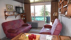 A cozy living room with two sofas, a coffee table, and a television. - 50m from ski slopes, 3rd floor, view village/ski slopes, balcony, parking, tv, ski locker, 42m² (Montgenèvre)